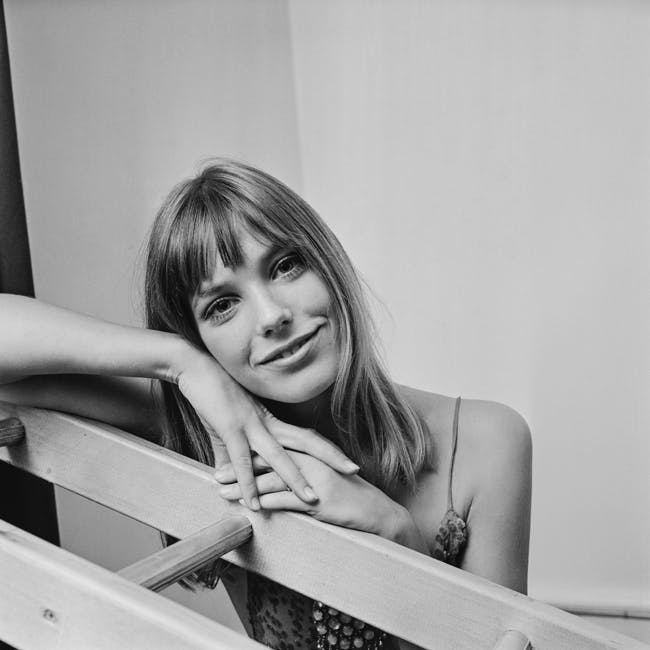 black & white photograph huty20830 1967 exp 1967 2058 one woman only half length eye contact posed leaning ladder smiling indoors hand on chin furniture person human skin